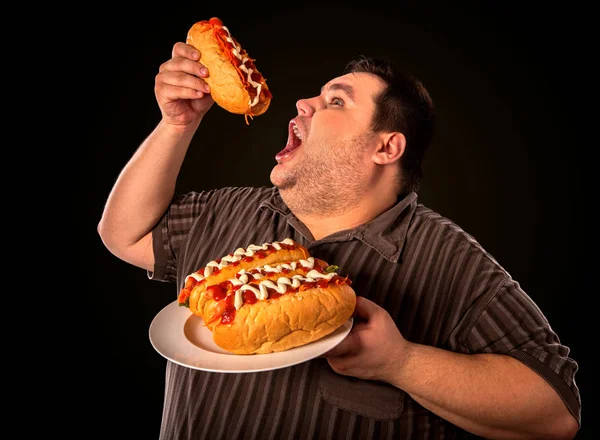 Gruby mężczyzna jedzenie fast food hot doga. Śniadanie dla osób otyłych. — Zdjęcie stockowe