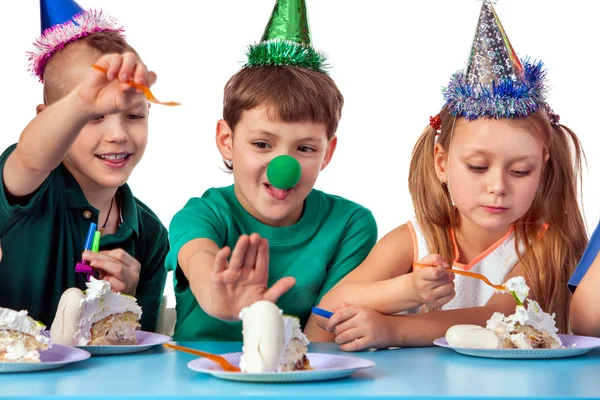As crianças de aniversário celebram a festa e comem bolo no prato juntos . — Fotografia de Stock