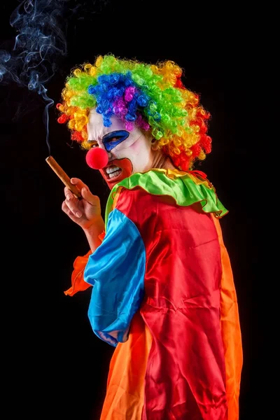 Halloween böser Clown auf schwarzem Hintergrund. Porträt einer rauchenden Frau. — Stockfoto