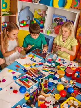 Kil çocuklar sınıfta modelleme hamuru. Okulda öğretmen öğretir.