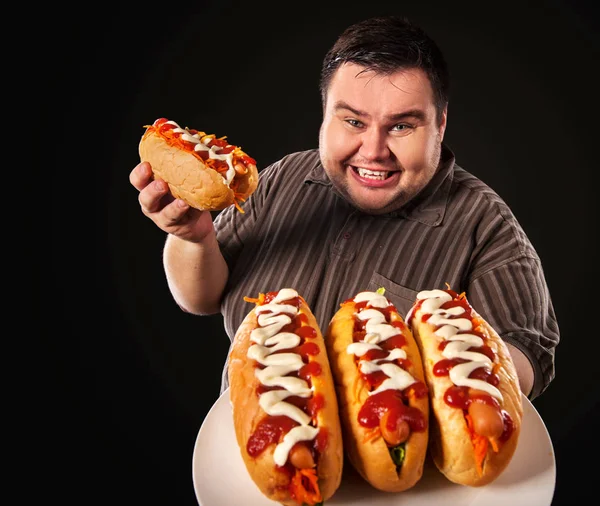 Tlustý muž jíst fast food v rohlíku. Snídaně pro osoby s nadváhou. — Stock fotografie
