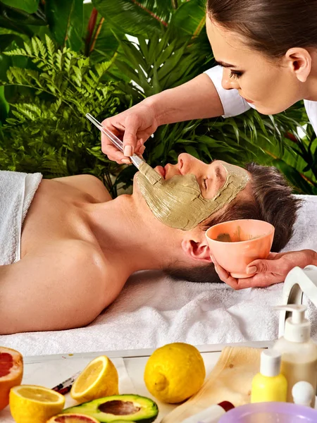 Modder masker van de mens in spa salon. Massage met klei volledig gezicht. — Stockfoto