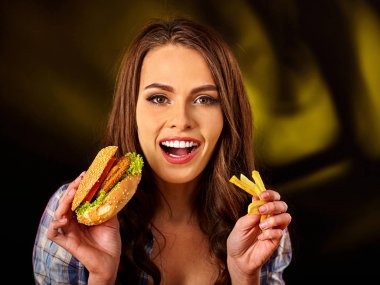 Patates kızartması ve hamburger masada yemek kadın.