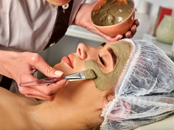 Máscara facial de barro de la mujer en el salón de spa. Masaje facial  . — Foto de Stock