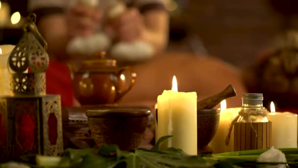 Young woman have hot poultice massage in spa salon with burning candles. — Stock Video