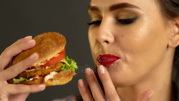 Frau isst Hamburger. Mädchen beißen sehr großen Burger — Stockvideo