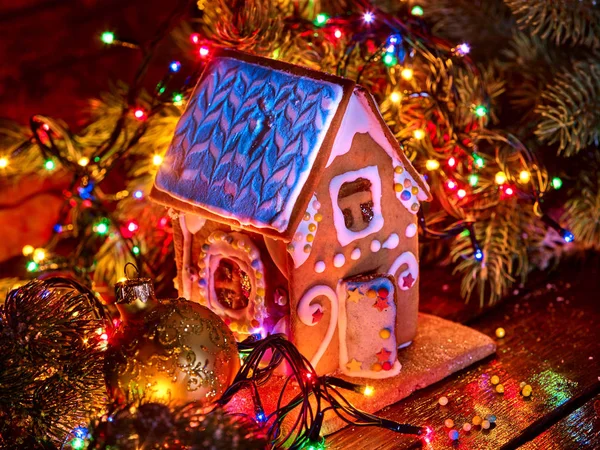 Casas de pan de jengibre con luces de Navidad cadena en la mesa de madera . —  Fotos de Stock