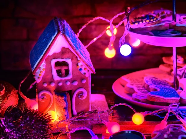 Candle light table with Christmas gingerbread house cookies . — Stock Photo, Image