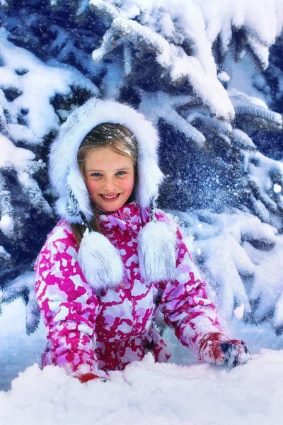 Inverno com neve para criança menina em roupas perto de árvore no parque . — Fotografia de Stock