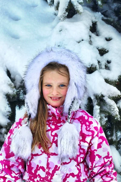 Inverno com neve para criança menina em roupas perto de árvore no parque . — Fotografia de Stock