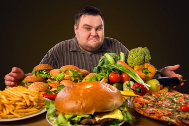 Diyet şişman adam sağlıklı ve sağlıksız gıda arasında seçim yapar.