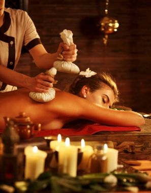 Kadın spa salonu masaj. Kadın topu terapi sıcak otlar var.