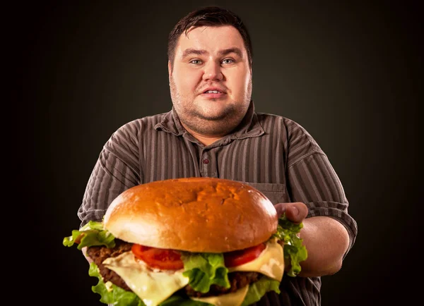 Gruby mężczyzna jedzenie fast food hamberger. Śniadanie dla osób otyłych. — Zdjęcie stockowe