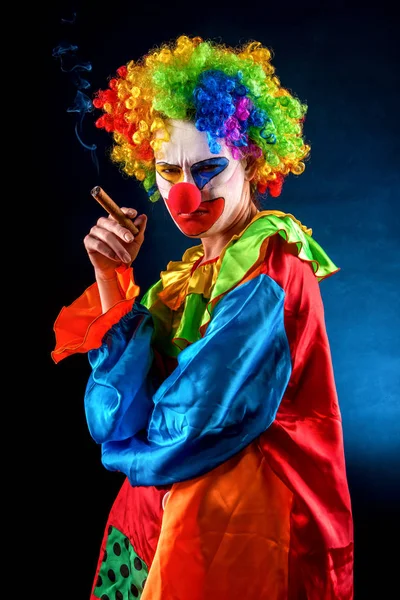 Böser Clown auf schwarzem Hintergrund. Porträt einer rauchenden Frau. — Stockfoto