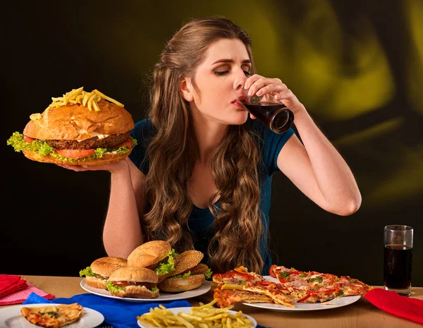 Frau isst Pommes und Hamburger auf Tisch. — Stockfoto