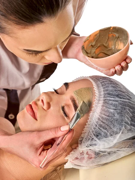 Máscara facial de barro de la mujer en el salón de spa. Masaje facial  . — Foto de Stock