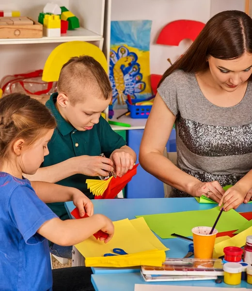 School kinderen met een schaar in handen van de kids snijden van papier . — Stockfoto