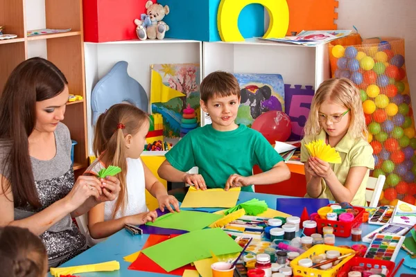 Niños de la escuela con tijeras en manos de niños cortando papel  . — Foto de Stock