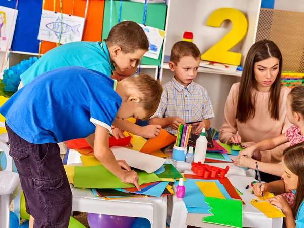 Écoliers avec ciseaux et papier couleur de coupe . — Photo