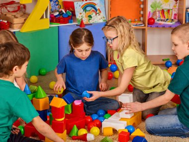 Anaokulunda çocuk yapı taşları. Oyuncak kat oynayan grup çocuklar.