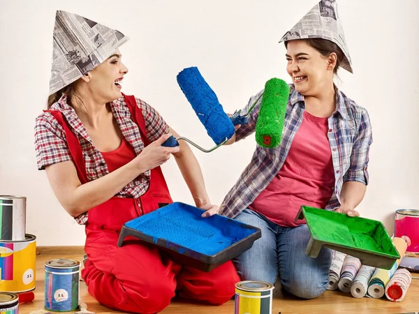 Repair home women holding bank with paint for wallpaper.