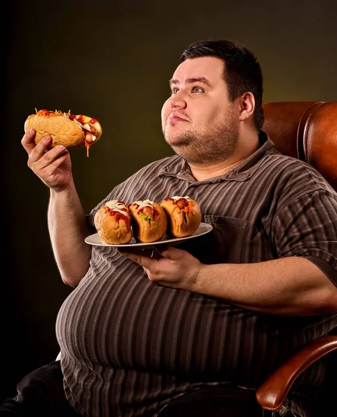 Homem gordo comendo cachorro quente fast food. Pequeno-almoço para pessoa com excesso de peso . — Fotografia de Stock