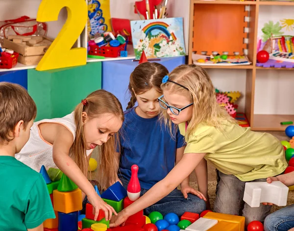 Crianças construindo blocos no jardim de infância. Grupo de crianças jogando chão de brinquedo  . — Fotografia de Stock