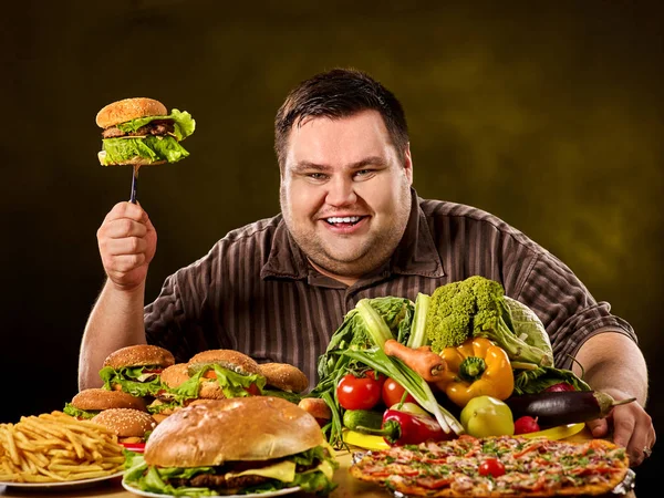 Tlouštík dietu činí volbu mezi zdravé a nezdravé jídlo. — Stock fotografie