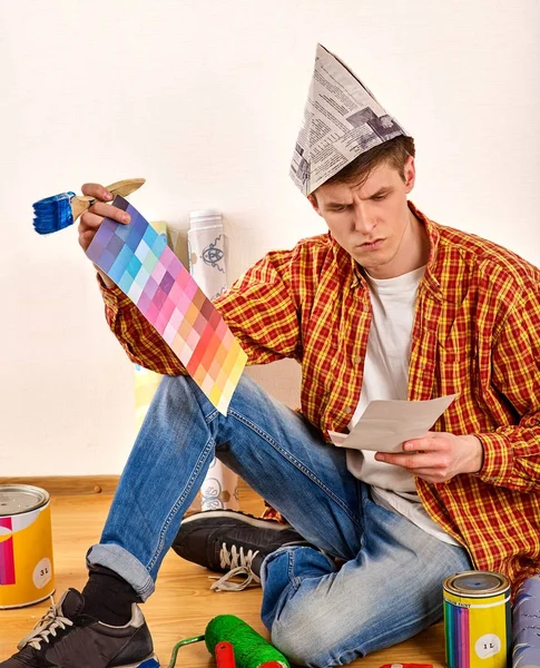 Oprava domů muž drží malířský váleček na tapety. — Stock fotografie