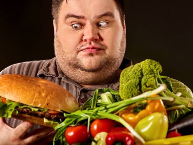 Diyet şişman adam sağlıklı ve sağlıksız gıda arasında seçim yapar.