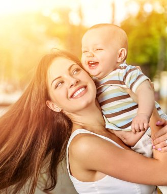 Anne ve açık havada bahar parkta mutlu bebek.