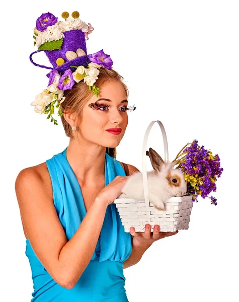 Жінка в великодньому стилі тримає кролика і квіти в кошику . — стокове фото