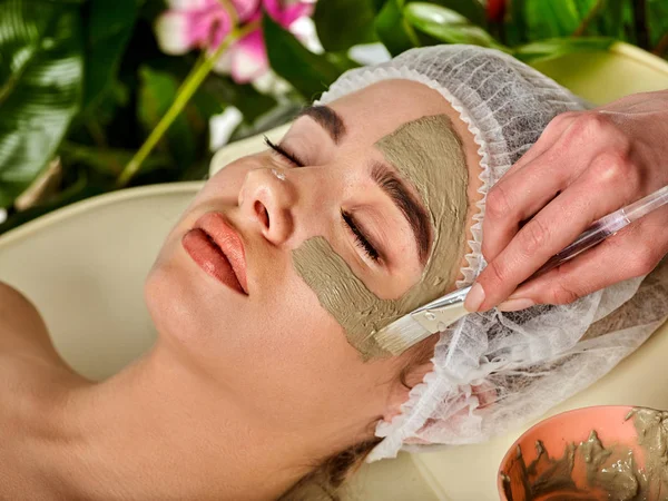 Máscara facial de barro de la mujer en el salón de spa. Masaje facial  . — Foto de Stock