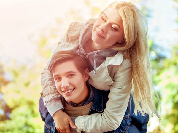 Pareja abrazándose en el parque de primavera y mirando cámara haciendo foto . —  Fotos de Stock