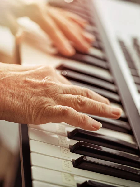 MIDI-клавіатури або електронний фортепіано і грає руками дитини. — стокове фото