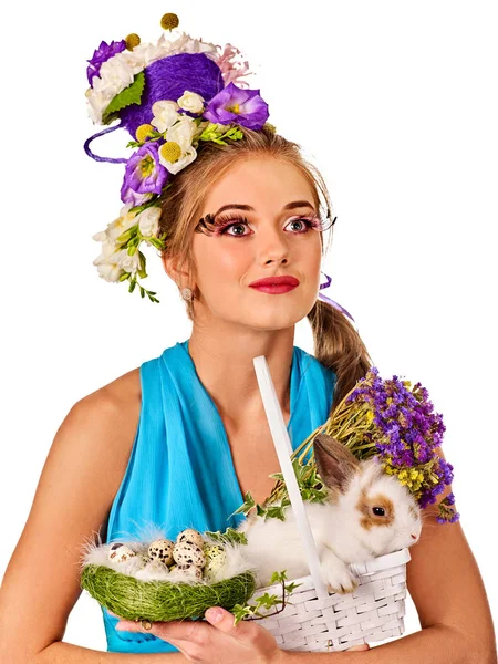 Vrouw in Pasen stijl holding konijn en bloemen in mand. — Stockfoto