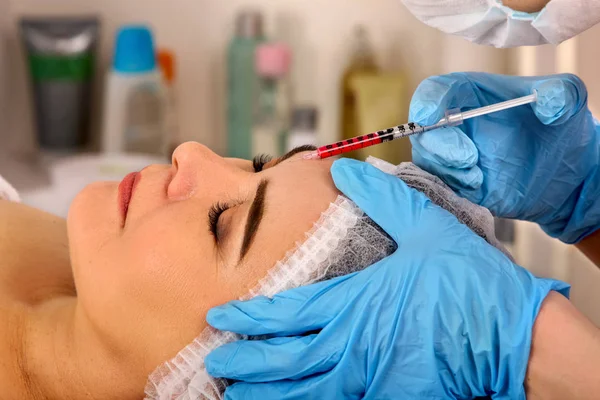 Dermale vullers lippen van vrouw in spa salon met schoonheidsspecialiste. — Stockfoto