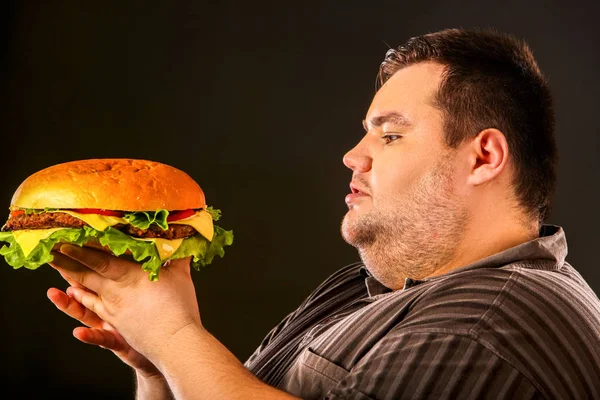 Fet man äter snabbmat hamberger. Frukost för överviktig person. — Stockfoto