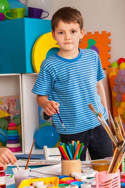 Liten studenter pojke målning i konst skola klass. — Stockfoto