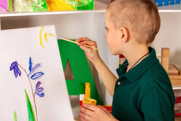 Enfant peignant doigt sur chevalet. Enfant garçon apprendre peinture école . — Photo