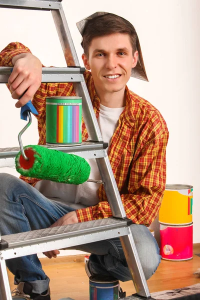 Oprava domů muž drží malířský váleček na tapety. — Stock fotografie