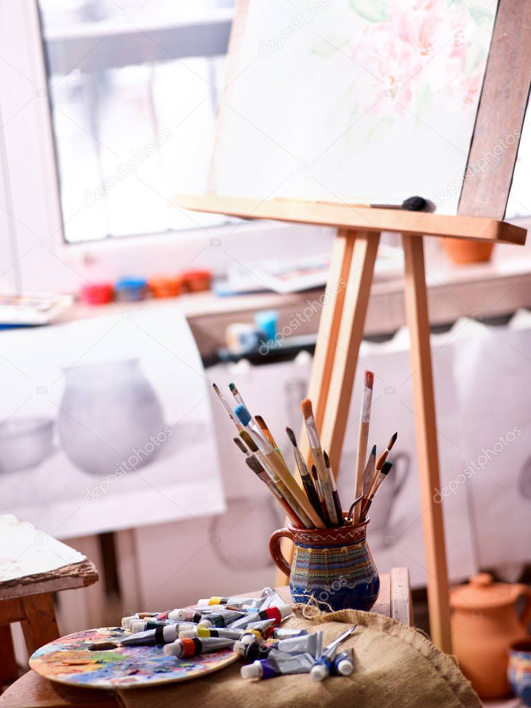 Authentic paint brushes still life on table in art class school.