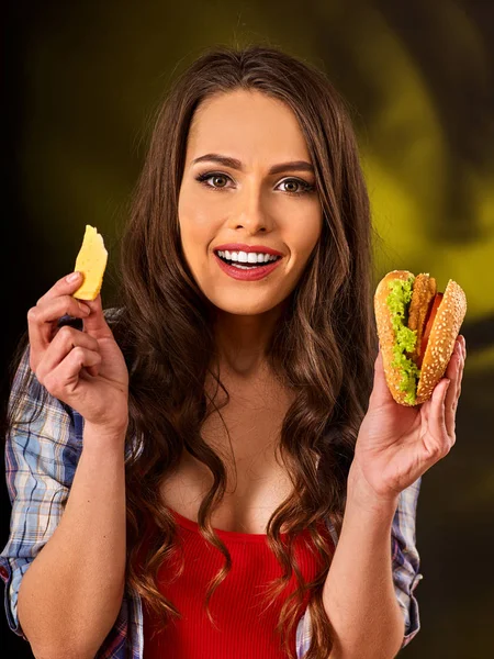 Donna mangiare patatine fritte e hamburger sul tavolo . — Foto Stock