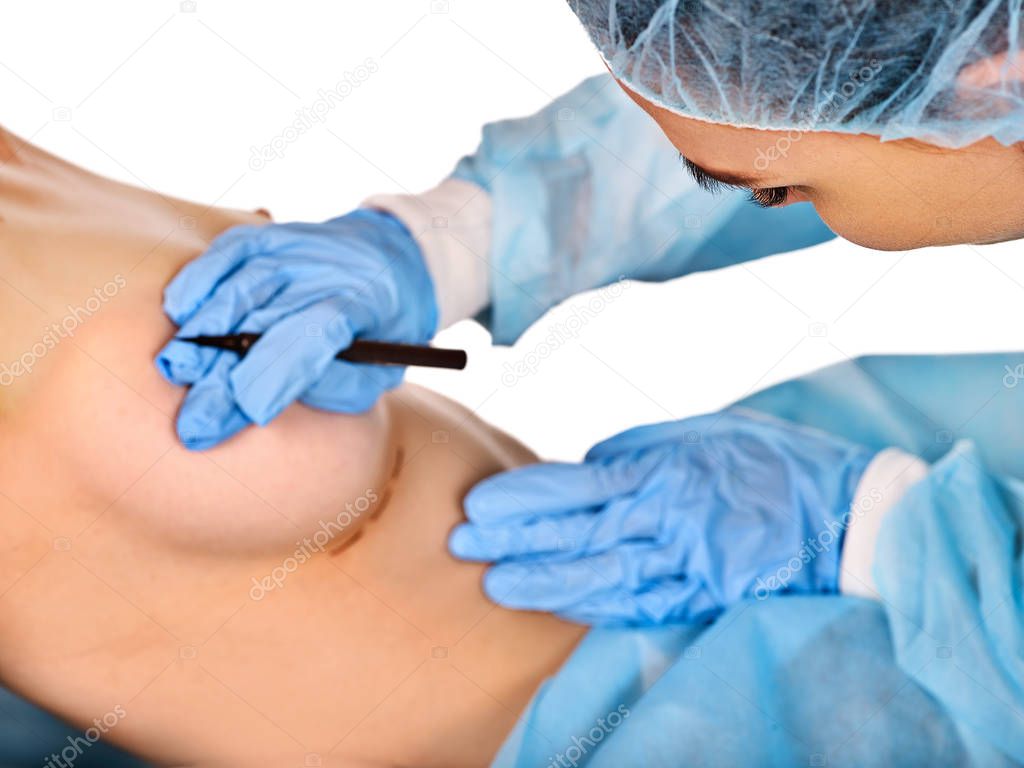 Breast enhancement surgery of body part. Doctor makes dotted line .