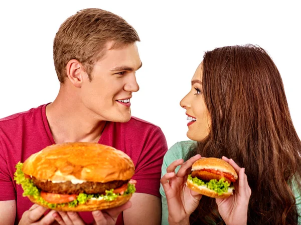 Casal a comer fast food. Homem e mulher comem hambúrguer com presunto . — Fotografia de Stock