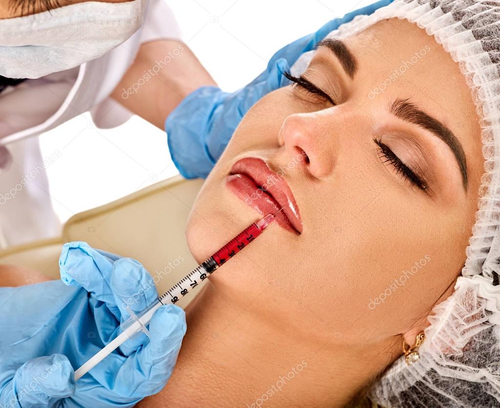 Dermal fillers lips of woman in spa salon with beautician.