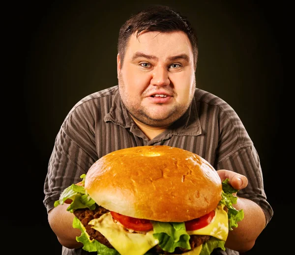 Hombre gordo comiendo hamburguesa de comida rápida. Desayuno para personas con sobrepeso . — Foto de Stock