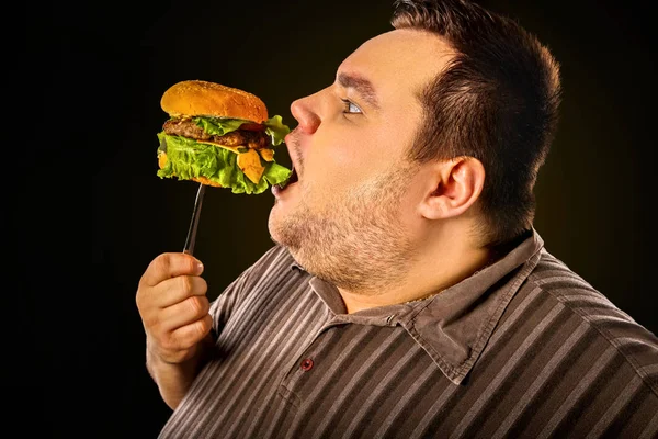 Hombre gordo comiendo hamburguesa de comida rápida. Desayuno para personas con sobrepeso . —  Fotos de Stock