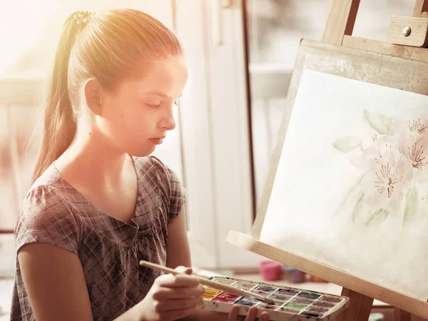 Artist painting on easel in studio. Girl paints with brush. — Stock Photo, Image