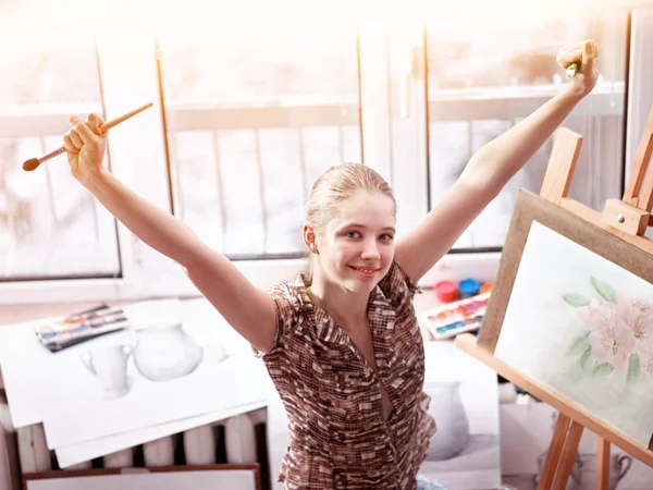 Künstler malen auf Staffelei im Atelier. Mädchen malt mit Pinsel. — Stockfoto